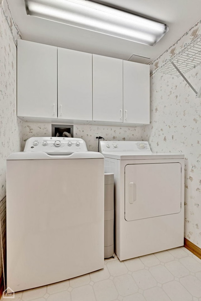 laundry room featuring wallpapered walls, washing machine and dryer, baseboards, and cabinet space