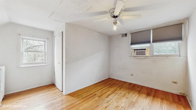 unfurnished bedroom featuring light wood-type flooring, cooling unit, visible vents, and a closet