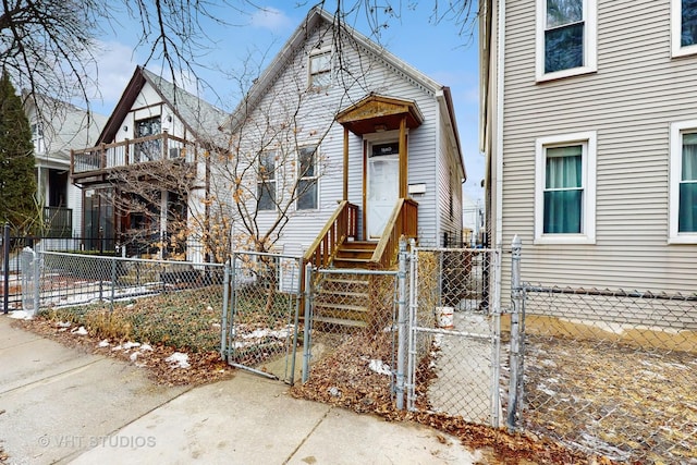 view of front facade with entry steps, a fenced front yard, and a gate