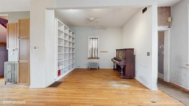 interior space featuring radiator heating unit, visible vents, and light wood-style floors