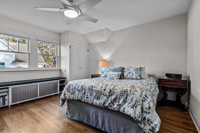 bedroom featuring a closet, radiator, ceiling fan, and wood finished floors