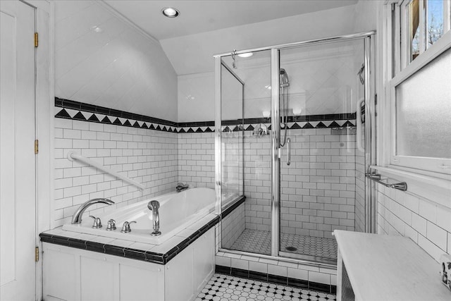 full bath featuring tile patterned flooring, tile walls, a bath, and a stall shower