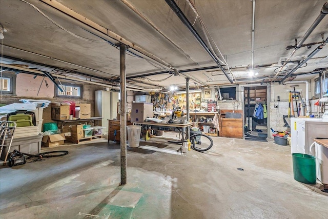 below grade area featuring washing machine and clothes dryer and a workshop area