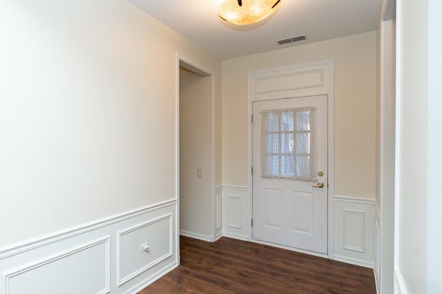 doorway to outside featuring wainscoting, visible vents, and dark wood finished floors