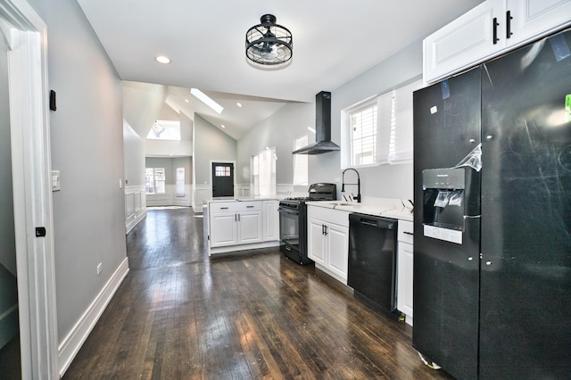 kitchen with white cabinets, wall chimney range hood, vaulted ceiling, black appliances, and a sink