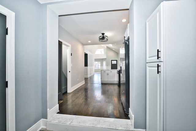 corridor with lofted ceiling, baseboards, dark wood-style floors, and recessed lighting