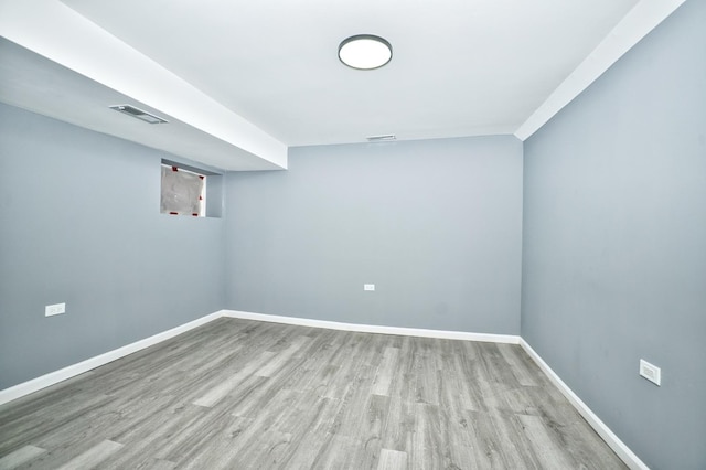 unfurnished room with visible vents, baseboards, and wood finished floors