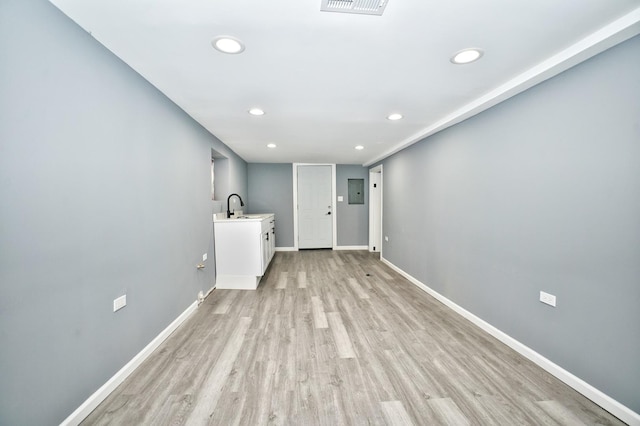 interior space featuring recessed lighting, a sink, light wood-style flooring, and baseboards