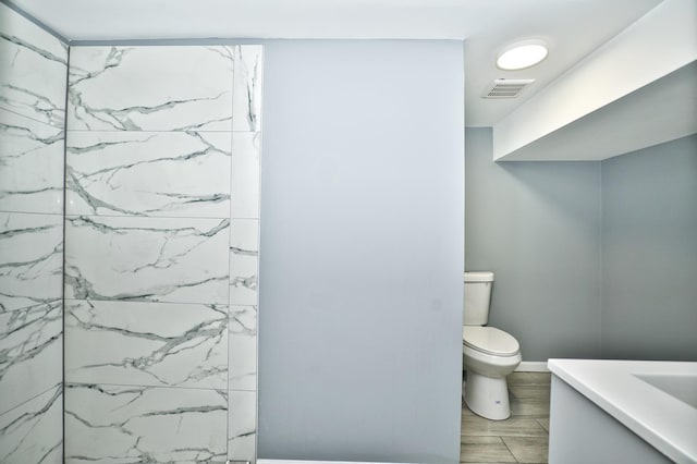 bathroom featuring toilet, wood finish floors, vanity, and visible vents