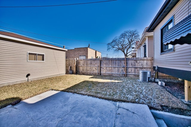 view of yard with cooling unit, fence, and a patio