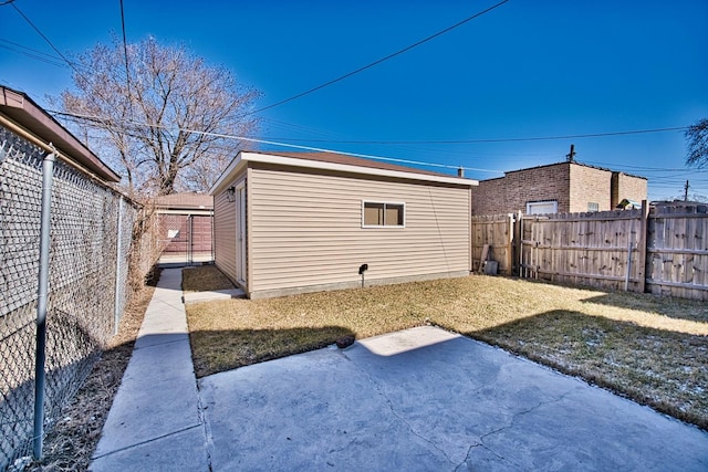 view of yard with an outbuilding, a patio area, and a fenced backyard