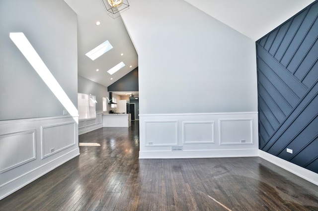 bonus room with a skylight, recessed lighting, a decorative wall, wood finished floors, and high vaulted ceiling