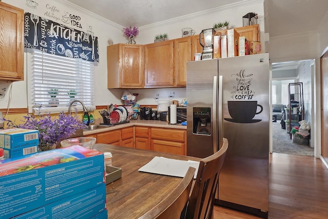 kitchen featuring ornamental molding, light wood-type flooring, a sink, and stainless steel fridge with ice dispenser