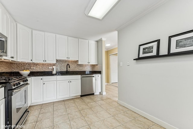 kitchen featuring tasteful backsplash, white cabinets, appliances with stainless steel finishes, crown molding, and a sink