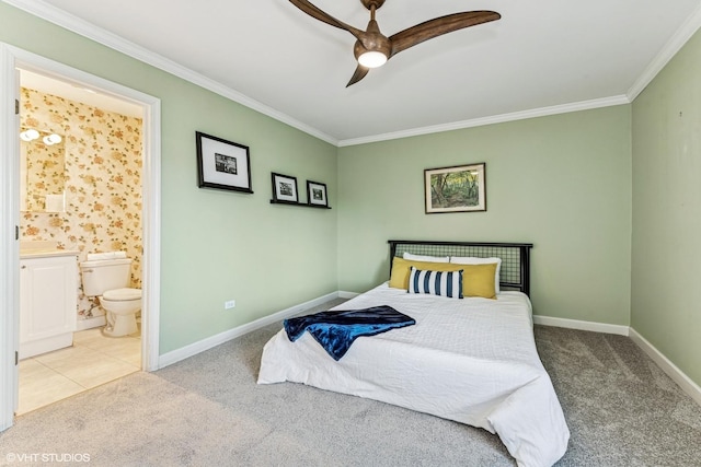 carpeted bedroom featuring baseboards, ceiling fan, ensuite bath, and crown molding