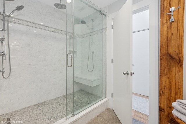 bathroom featuring tile patterned flooring and a shower stall