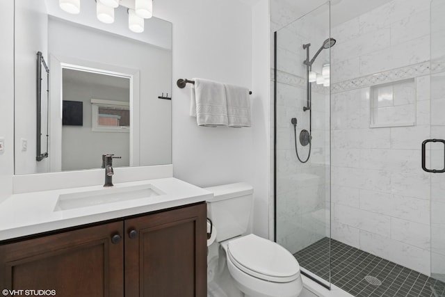 bathroom with toilet, a stall shower, and vanity