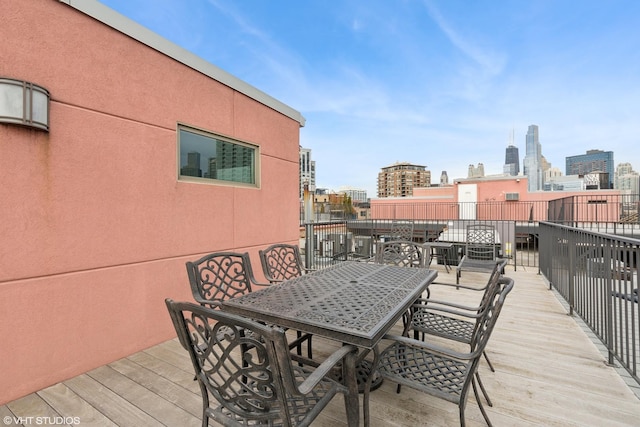 deck with a city view and outdoor dining space