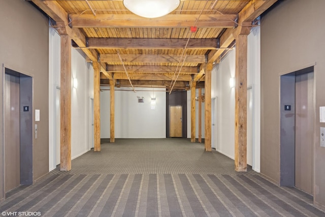 below grade area featuring carpet floors, elevator, and wooden ceiling