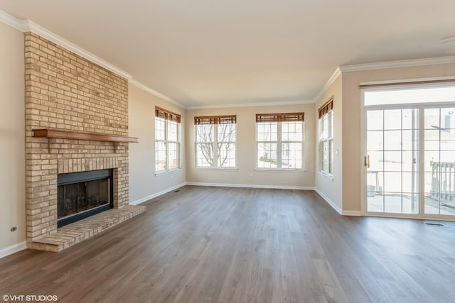 unfurnished living room with baseboards, wood finished floors, ornamental molding, and a fireplace