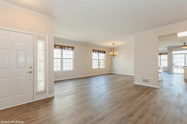 foyer entrance featuring crown molding, wood finished floors, visible vents, and a chandelier