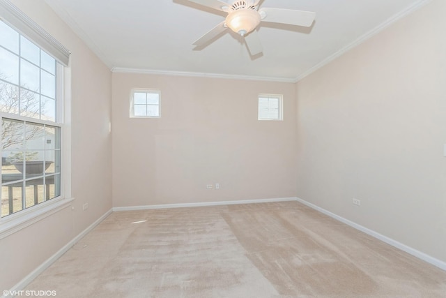 unfurnished room featuring light carpet, ceiling fan, crown molding, and baseboards