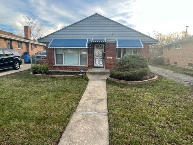 bungalow-style house with brick siding and a front lawn