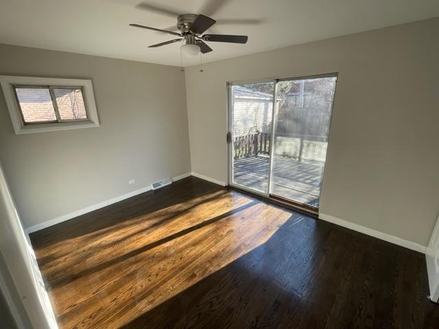 spare room with ceiling fan, dark wood-style flooring, and baseboards