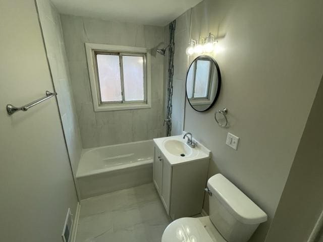 bathroom featuring marble finish floor, bathing tub / shower combination, vanity, and toilet