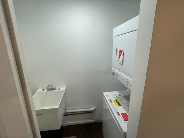 washroom featuring laundry area, a sink, and stacked washing maching and dryer