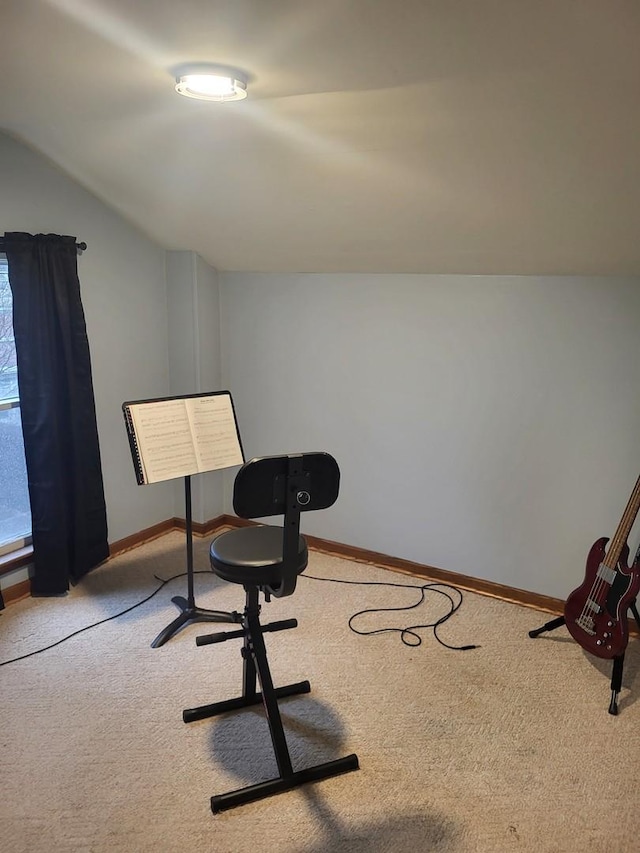 interior space with carpet, vaulted ceiling, and baseboards