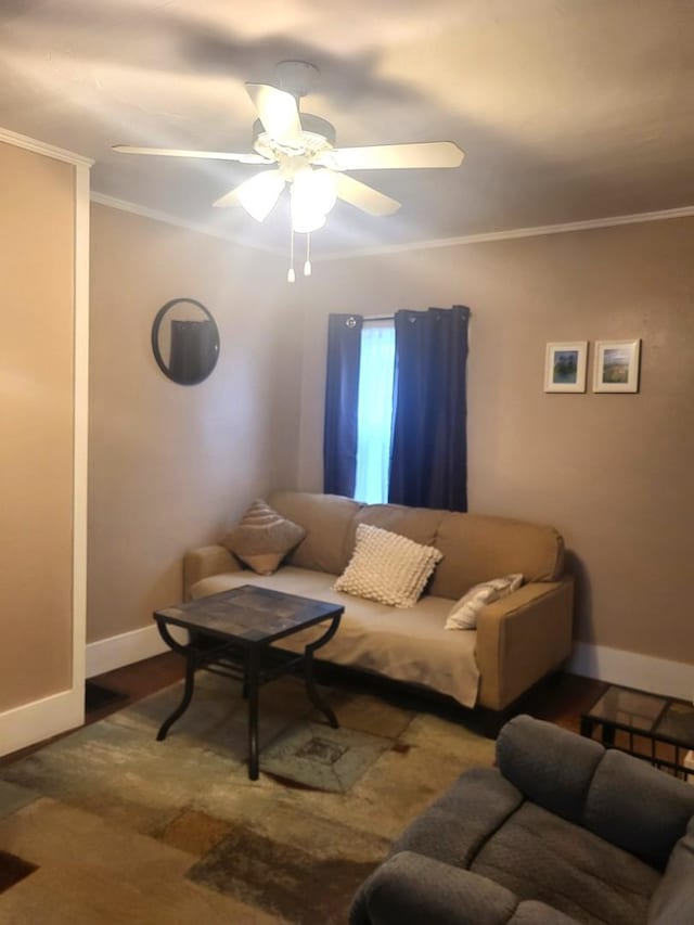 living room with ornamental molding, a ceiling fan, and baseboards