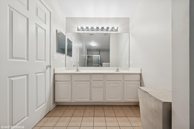 bathroom featuring tile patterned flooring, a sink, and double vanity