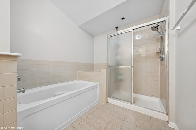 full bathroom featuring a stall shower, tile patterned flooring, and a bath