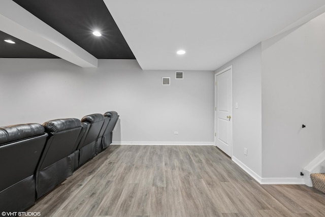 home theater featuring wood finished floors, visible vents, and baseboards