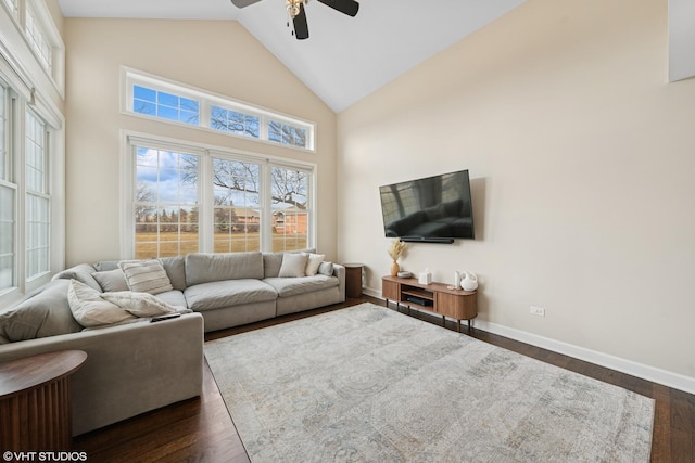 living room with high vaulted ceiling, a ceiling fan, baseboards, and dark wood-style flooring