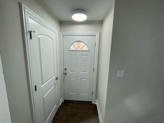 entryway with dark wood-style flooring and baseboards