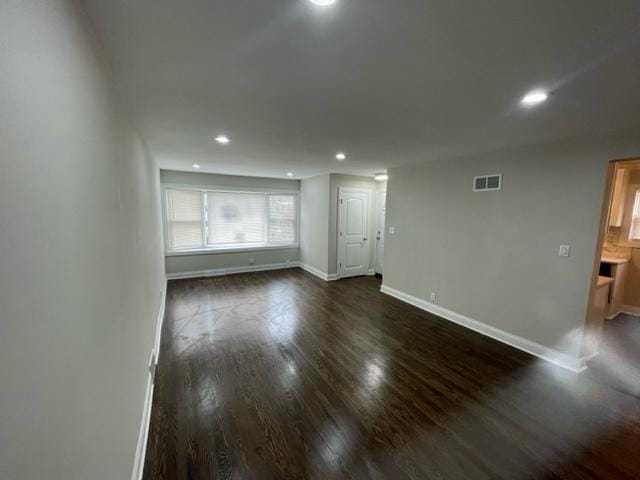 spare room with recessed lighting, visible vents, dark wood finished floors, and baseboards