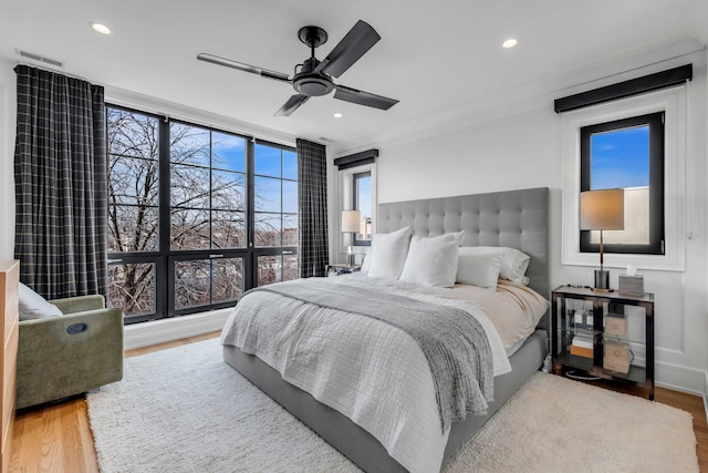 bedroom with ceiling fan, light wood-style flooring, a wall of windows, and recessed lighting