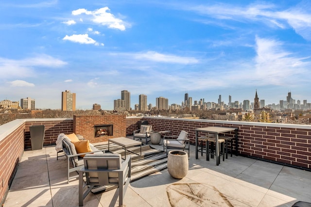 view of patio / terrace featuring a view of city and an outdoor brick fireplace