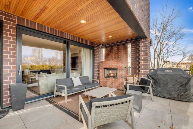 view of patio / terrace with an outdoor living space with a fireplace and grilling area