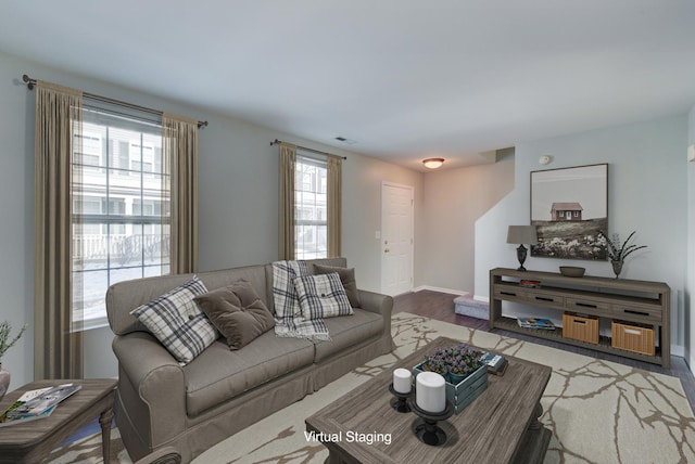 living room with wood finished floors, visible vents, and baseboards