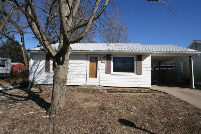 view of front of house with driveway, metal roof, and a carport