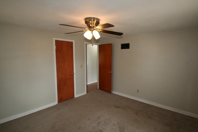 empty room with carpet floors, baseboards, visible vents, and ceiling fan