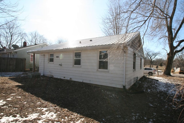 rear view of house with fence and metal roof