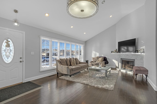 living room featuring baseboards, a fireplace, visible vents, and dark wood finished floors