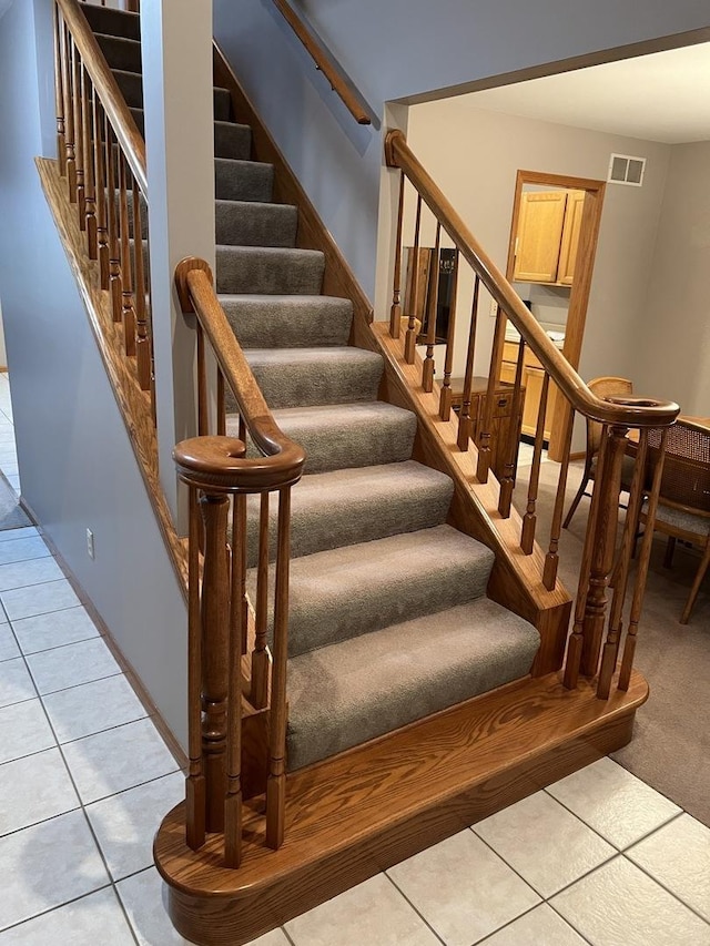 staircase featuring tile patterned flooring and visible vents