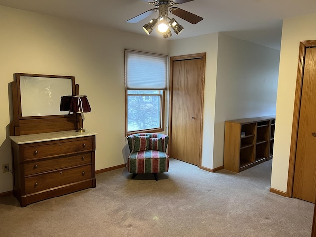 living area with baseboards, carpet floors, and ceiling fan