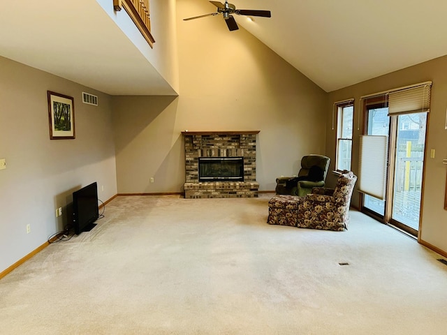 living area with visible vents, a brick fireplace, carpet, and a towering ceiling