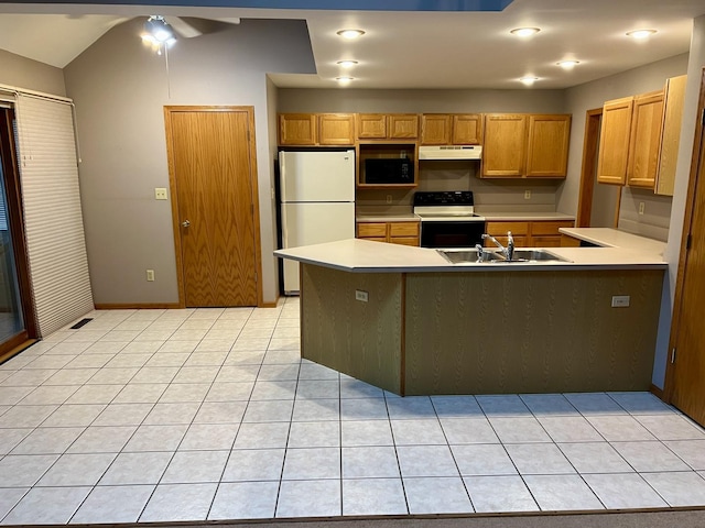 kitchen with a peninsula, freestanding refrigerator, a sink, under cabinet range hood, and range with electric stovetop